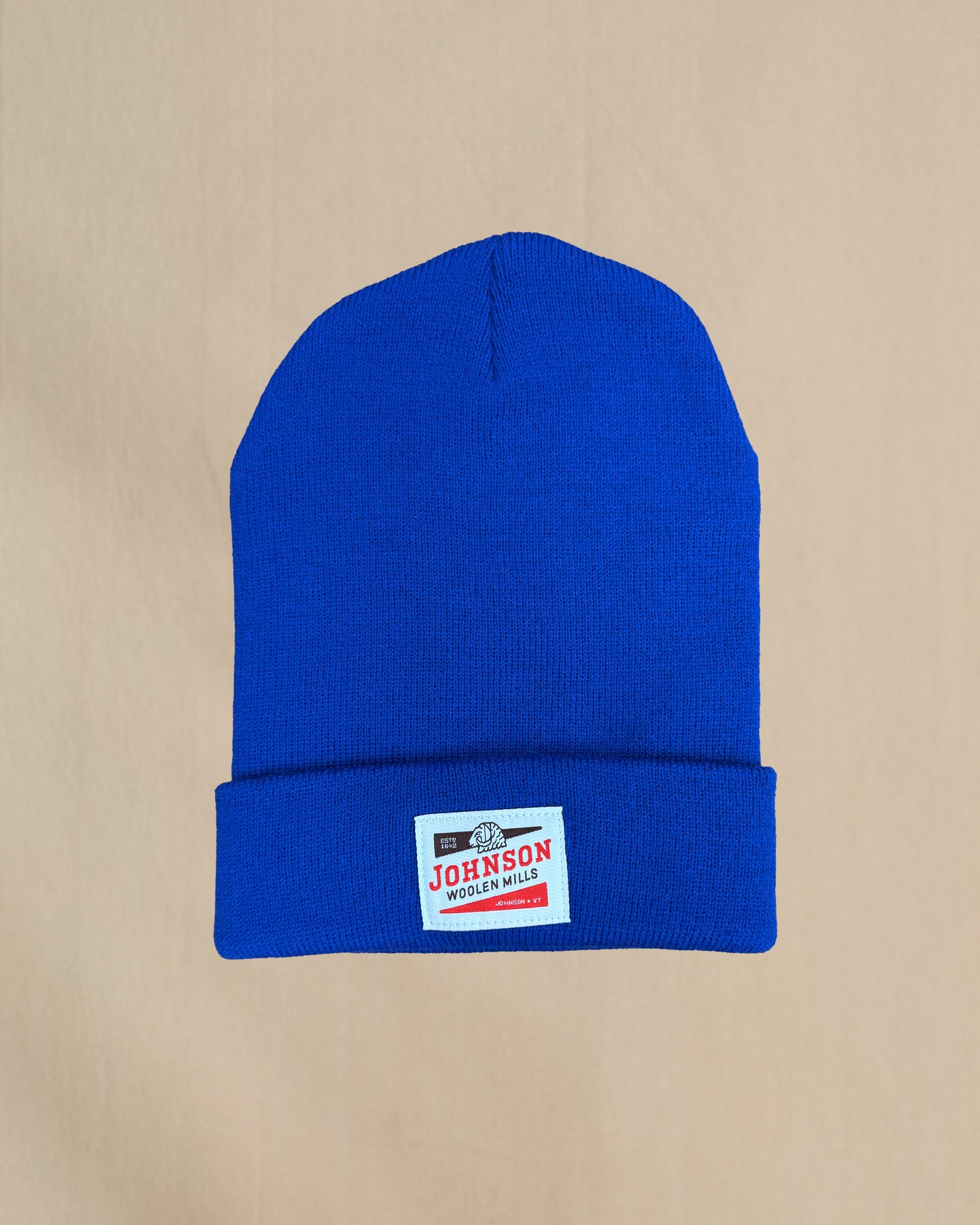 Blue beanie with a Johnson label on a beige background