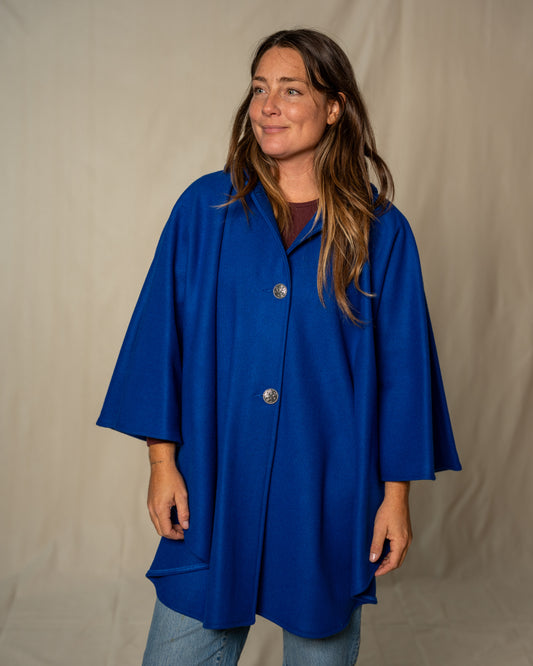 Woman wearing a blue coat against a plain background