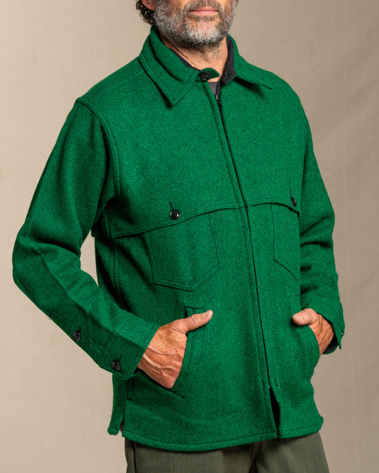 Man wearing a green twill wool jacket against a beige background