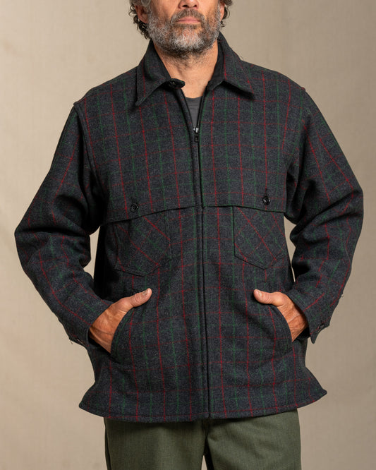 Man wearing a Adirondack plaid wool jacket against a beige background