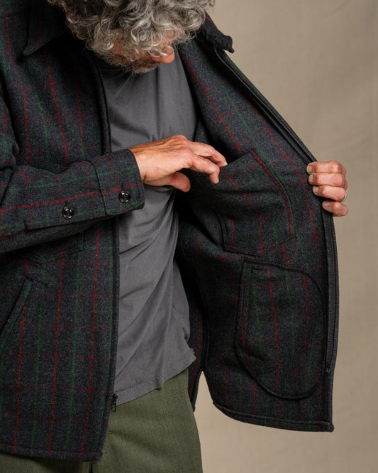 Man wearing a Adirondack plaid wool jacket against a beige background