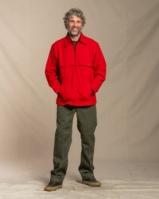 Man wearing a red wool jacket against a beige background