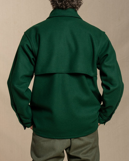 Man wearing a spruce green wool jacket against a beige background