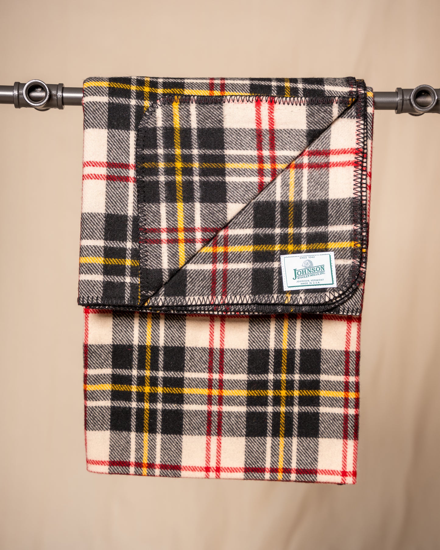 Johnson Woolen Mills throw - black, white yellow plaid with red stitching and logo