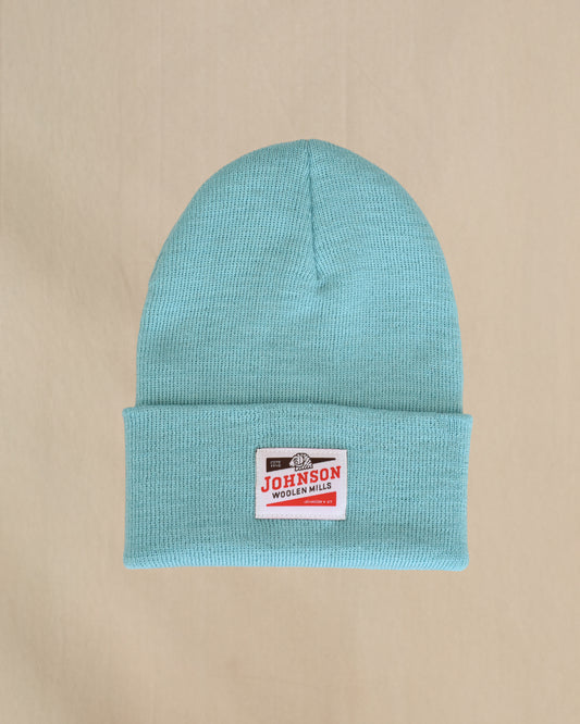 Merino Wool beanie in Canal blue with a Johnson label on a beige background