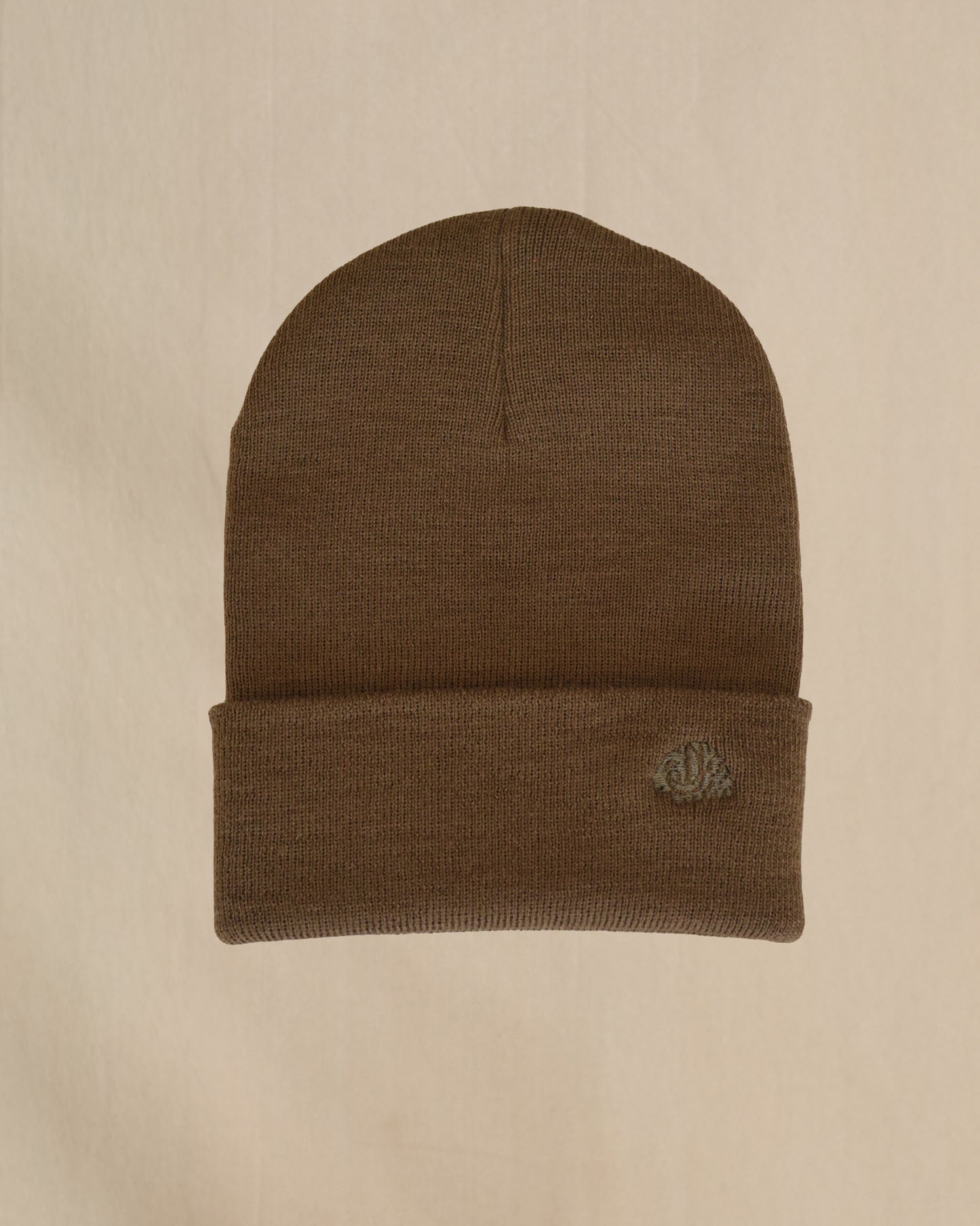 Coyote brown merino wool beanie on a beige background