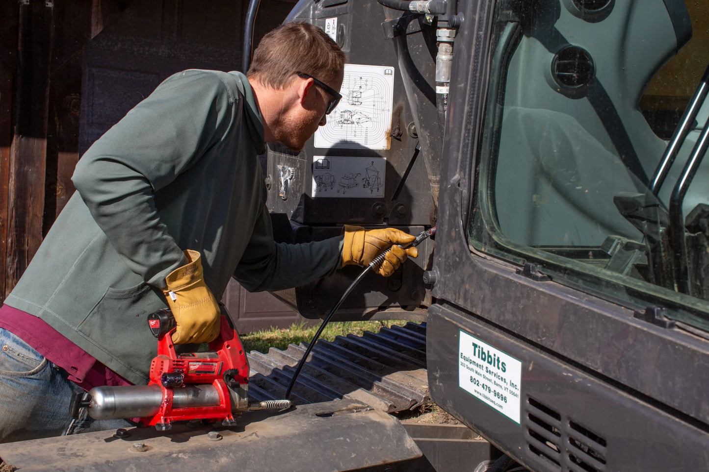 Person using a red air compressor on a vehicle