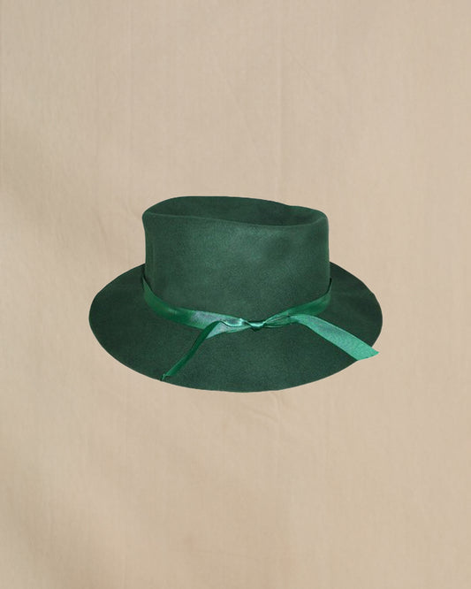 Green hat with a ribbon on a beige background