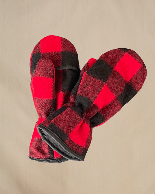 Red and black checkered mittens on a beige background
