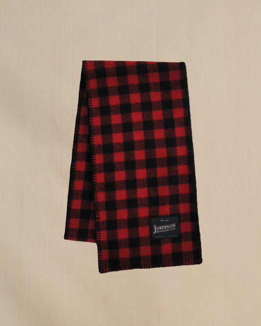 Red and black checkered scarf with a Johnson label on a beige background