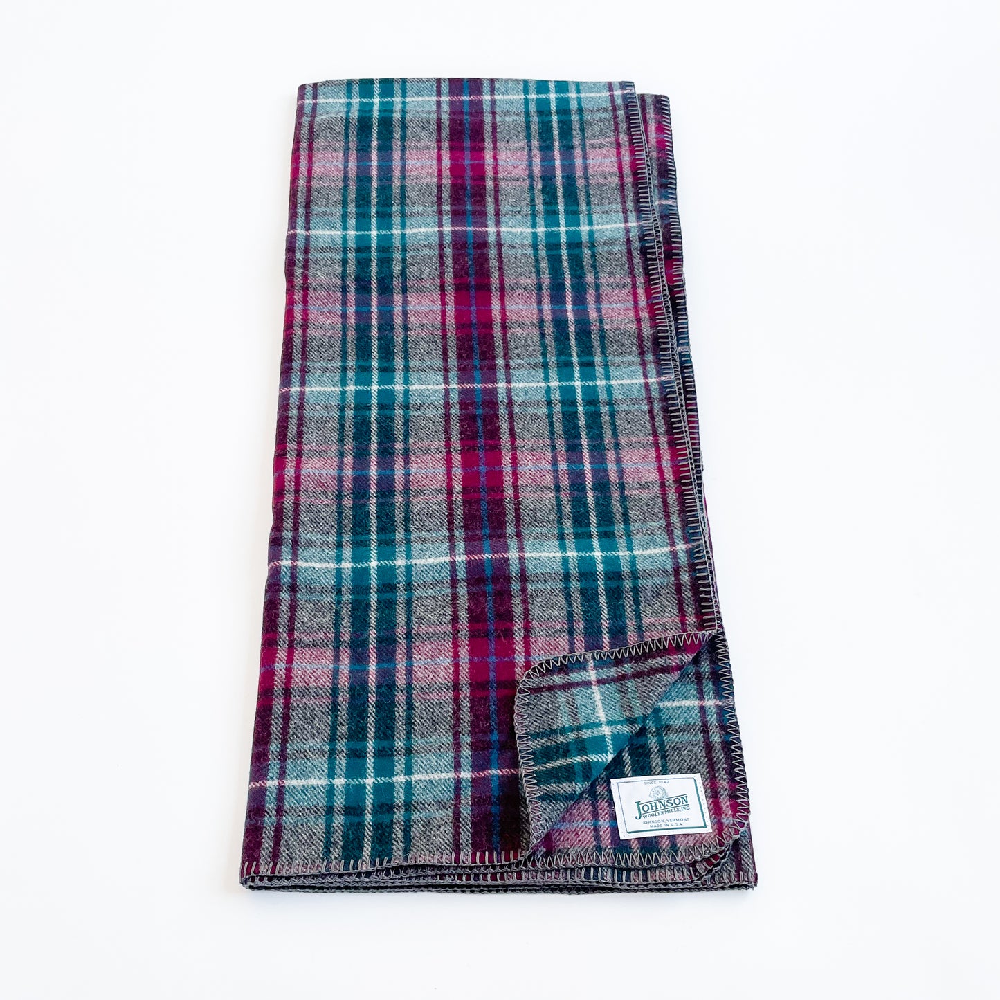 Johnson Woolen Mills Wine Gray Teel Plaid folded blanket length wise showing logo patch