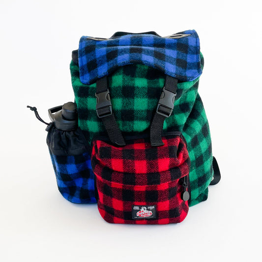 Wool back pack in multi color patchwork, shown with water bottle in side pocket
