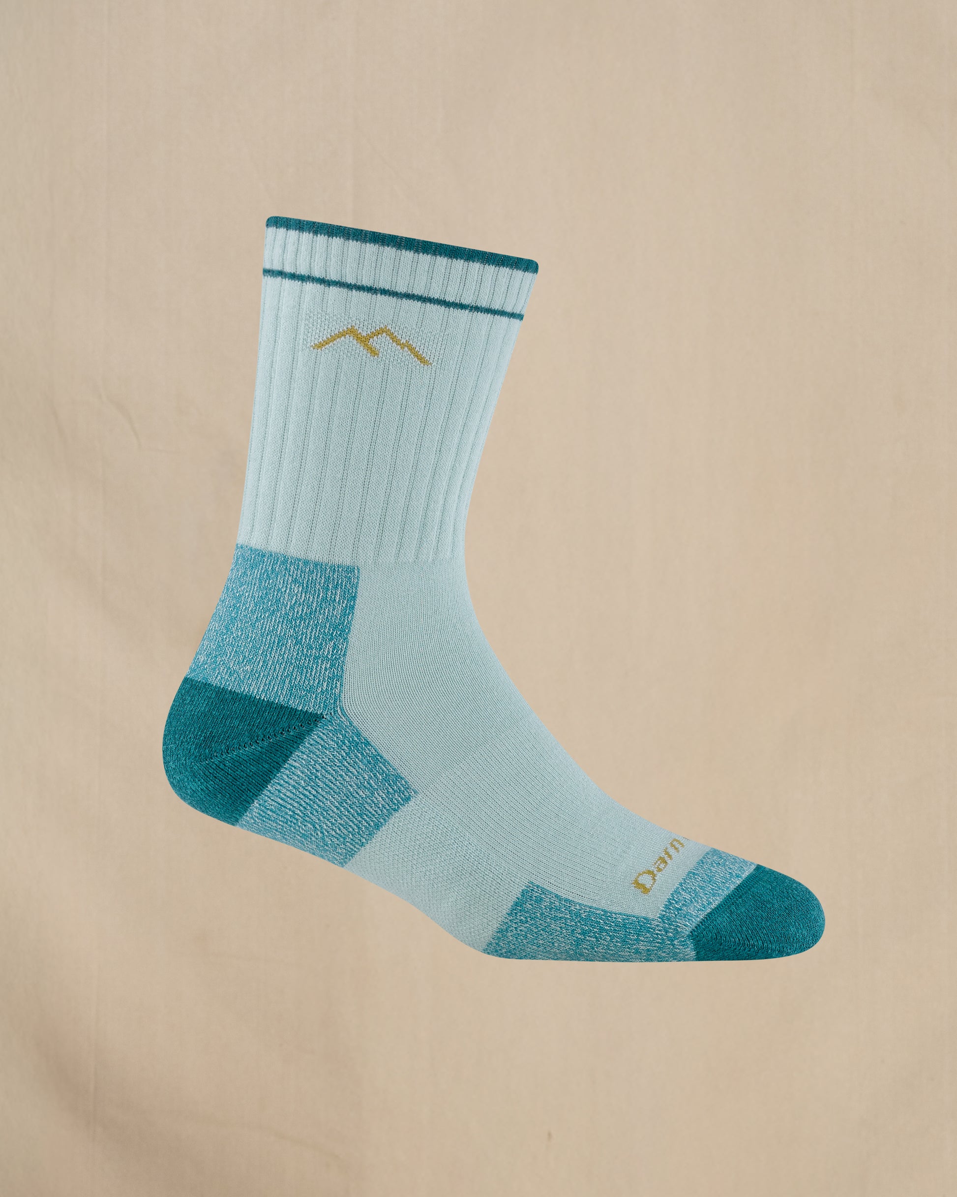 Light blue and green sock with a mountain logo on a beige background