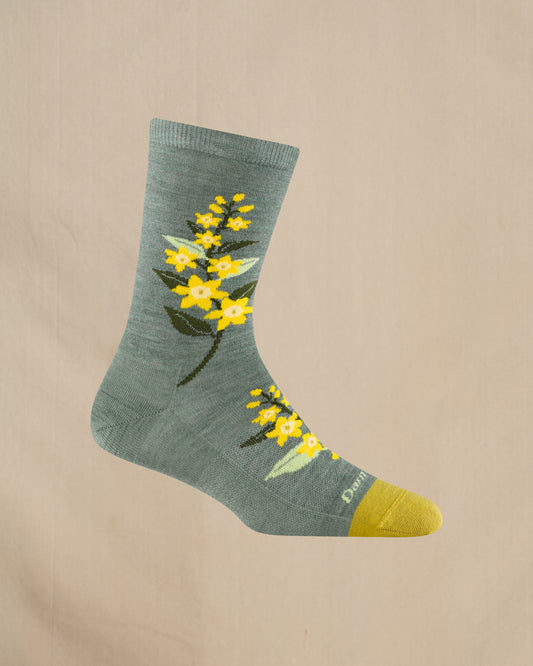 Green sock with yellow floral design on a beige background