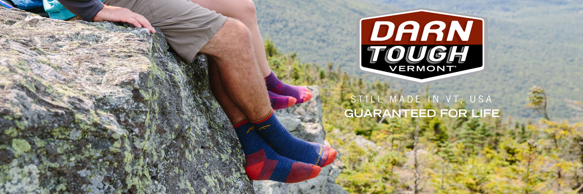 Darn Tough Socks Hike Banner view two people sitting on a cliff