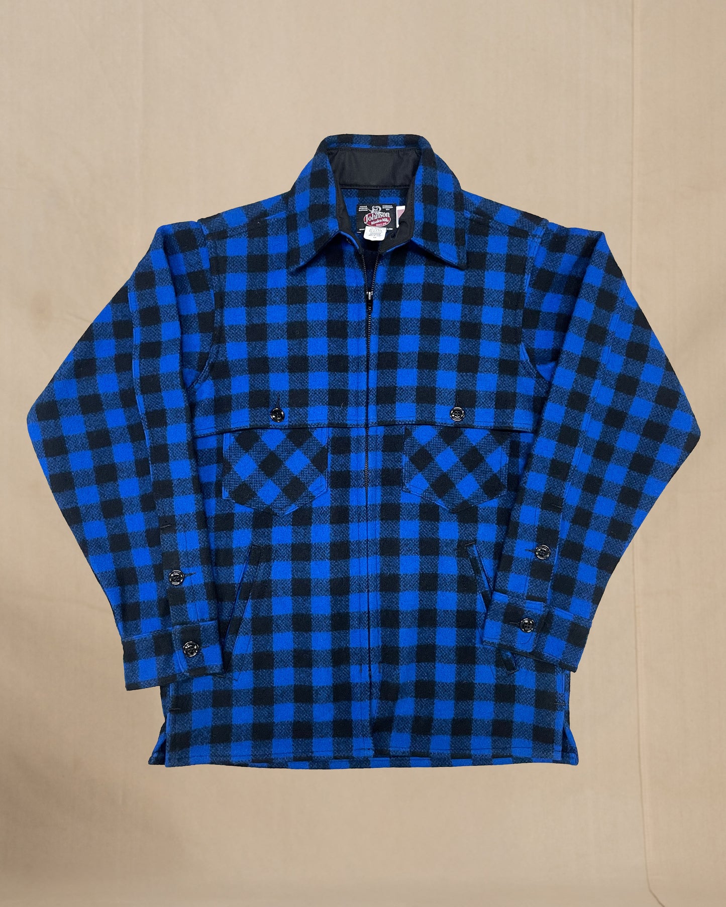 Blue and black checkered wool jac shirt on a beige background
