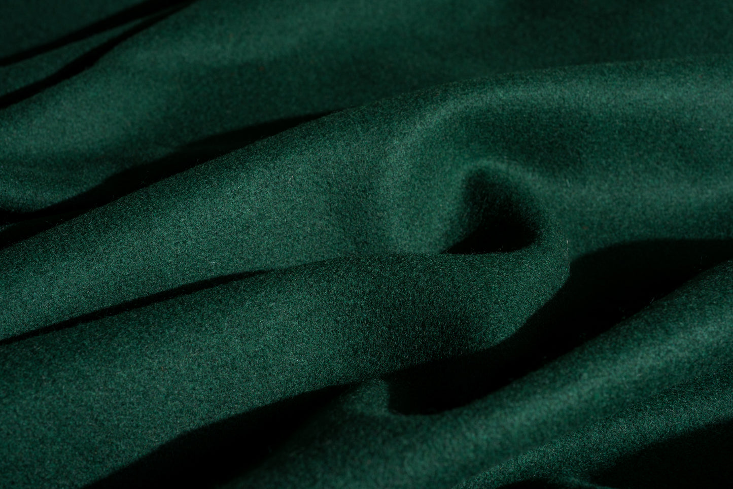 Dark spruce green wool fabric with a soft, slightly lustrous texture, shown in close-up folds.