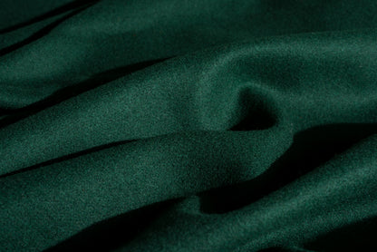 Dark spruce green wool fabric with a soft, slightly lustrous texture, shown in close-up folds.
