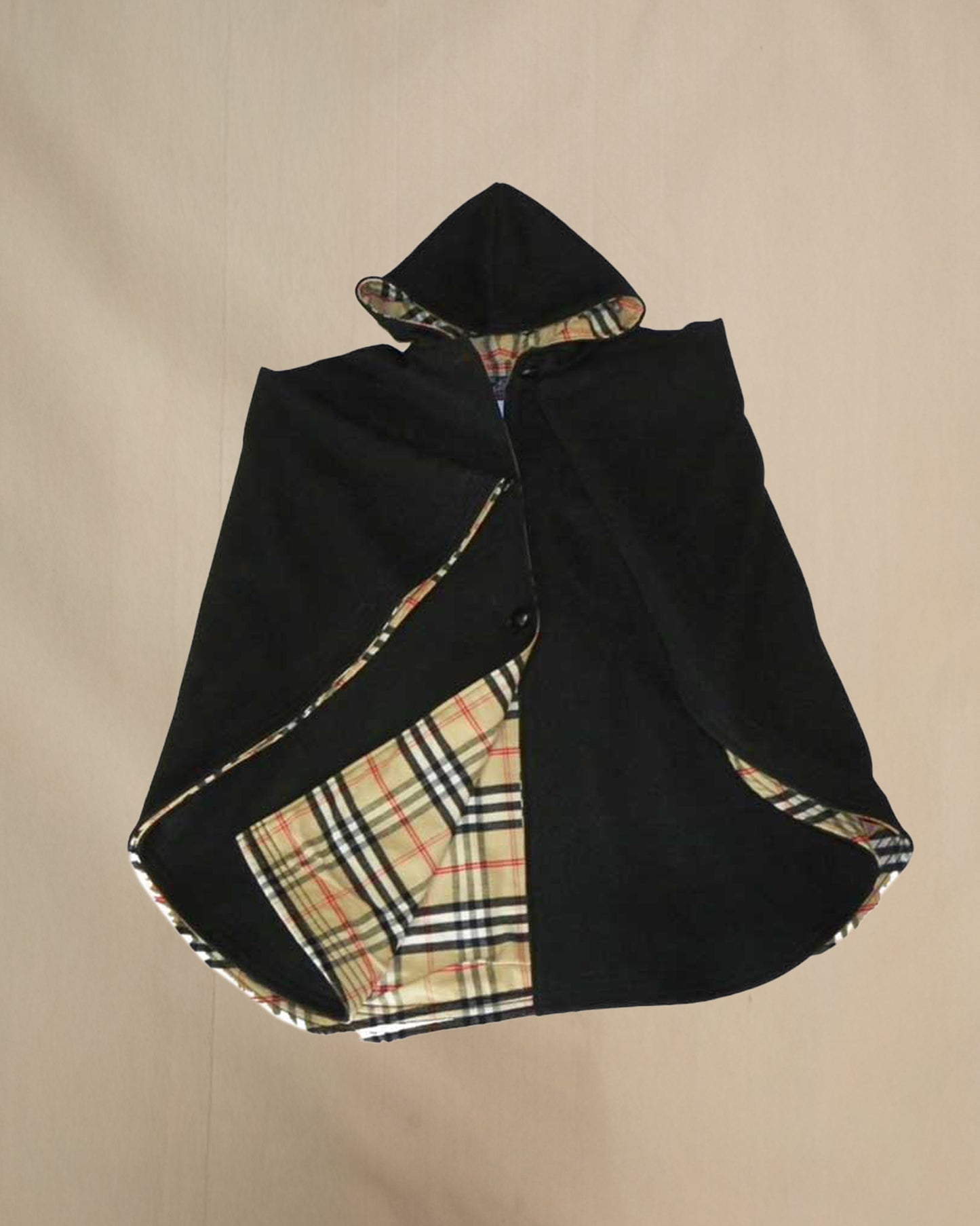 Black cape with plaid pattern on a beige background