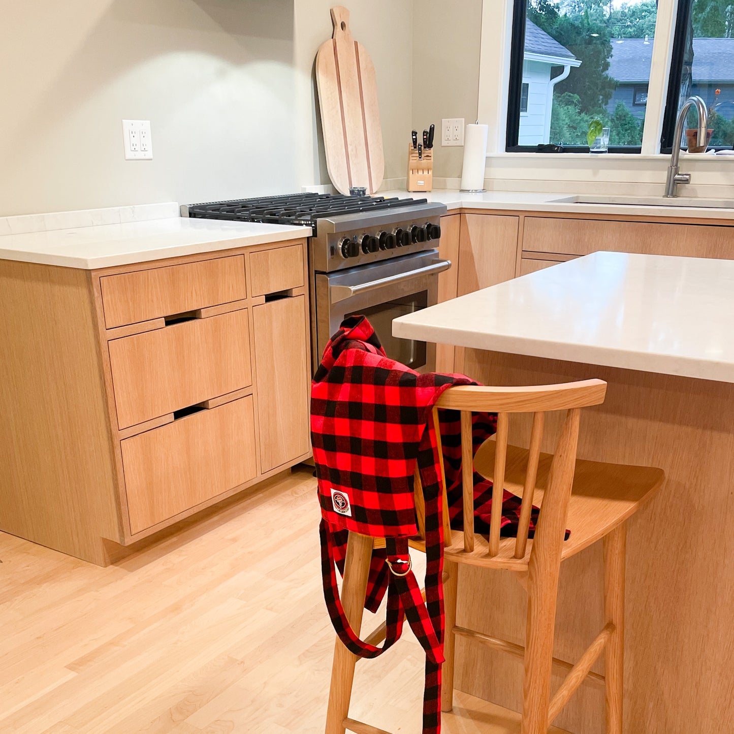 red and black buffalo check flannel apron hanging on chair in kitchen