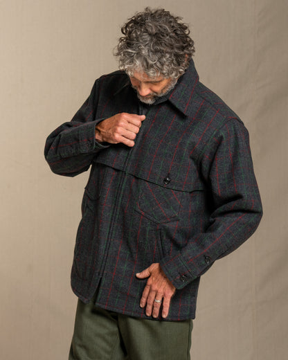 Man wearing a Adirondack plaid wool jacket against a beige background