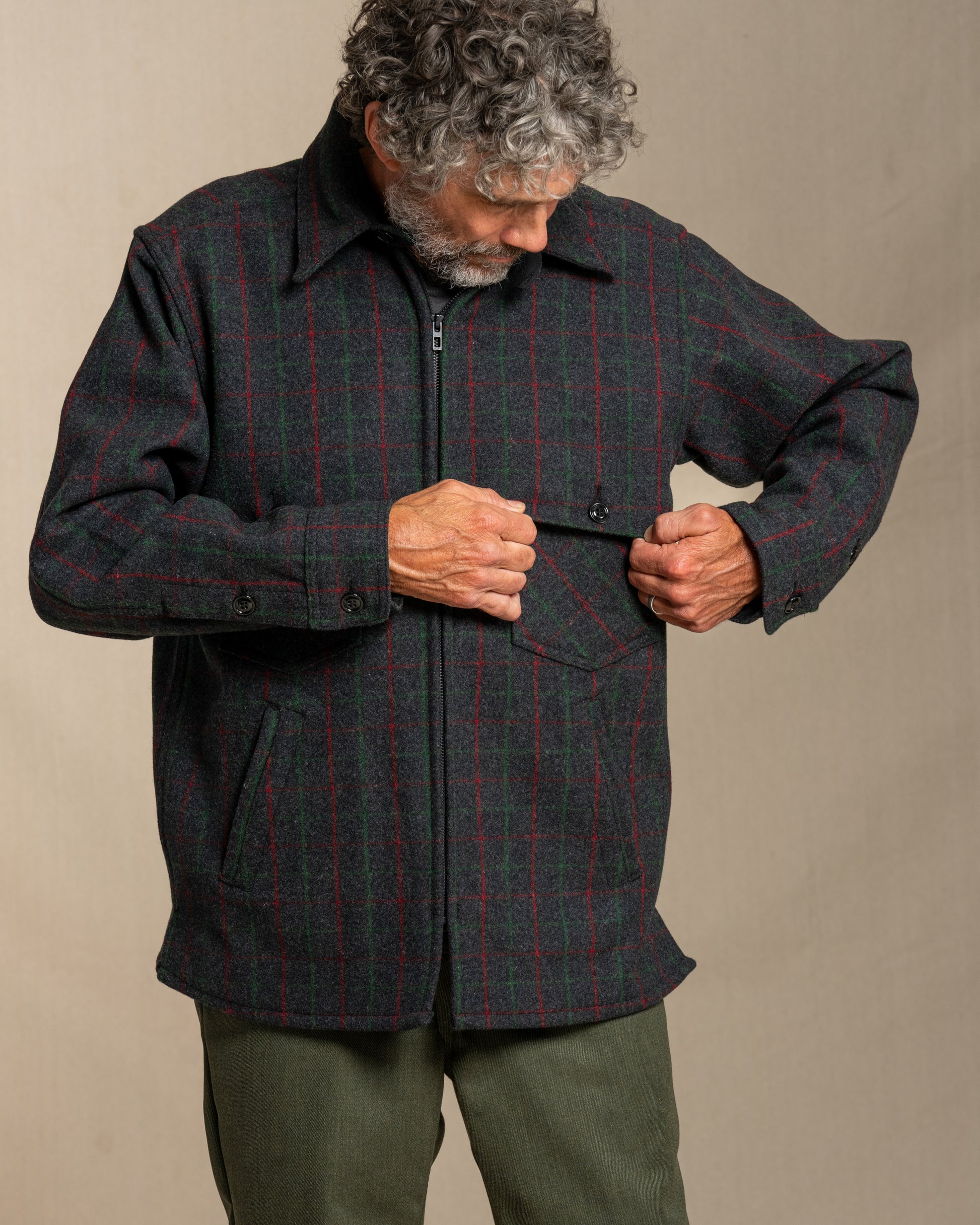 Man wearing a Adirondack plaid wool jacket against a beige background