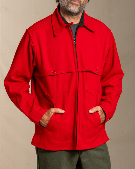 Man wearing a red wool jacket against a beige background
