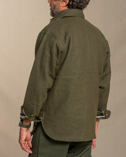 Man wearing a loden wool shirt with plaid flannel lining against a beige background