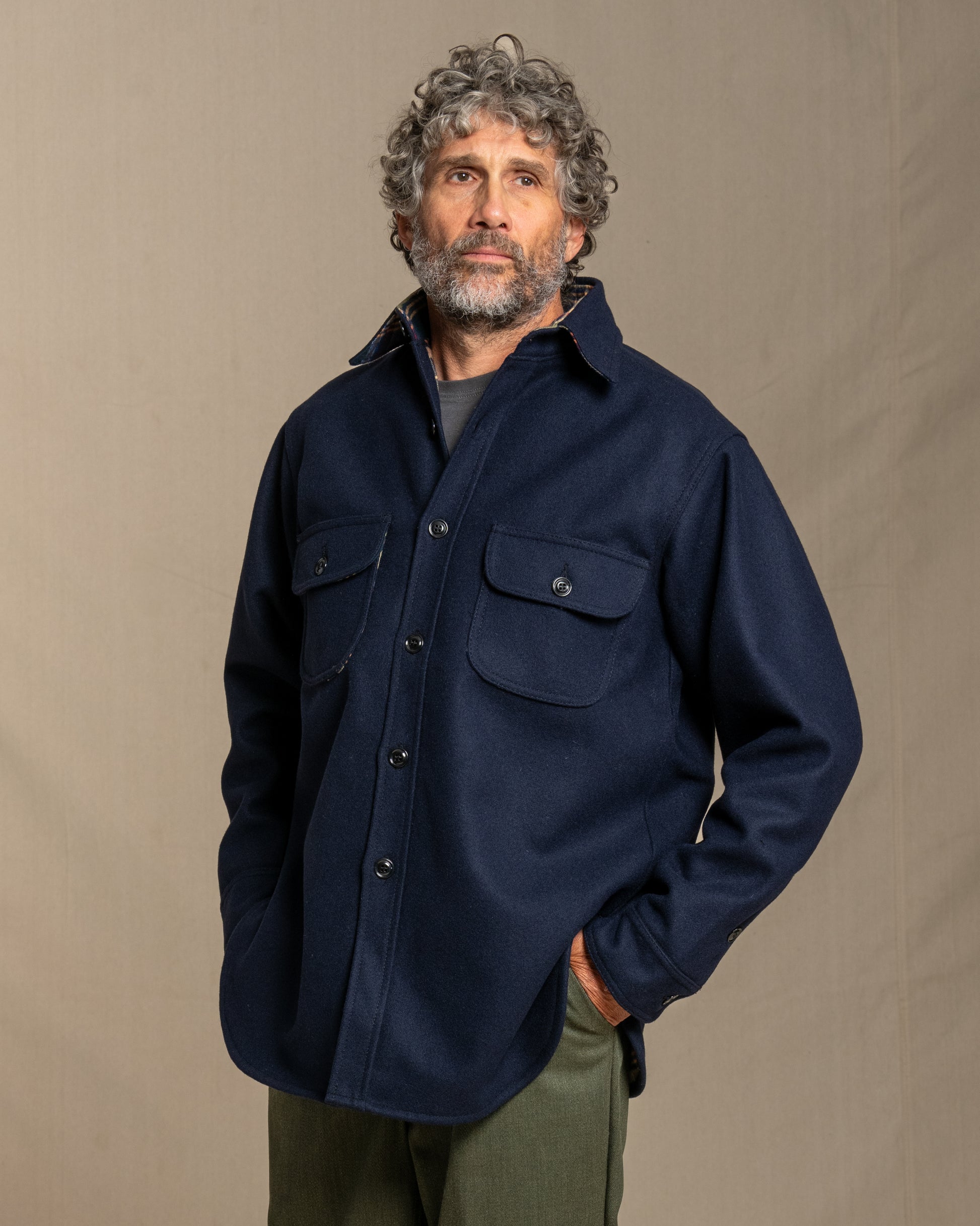 Man wearing a navy blue wool shirt against a canvas background