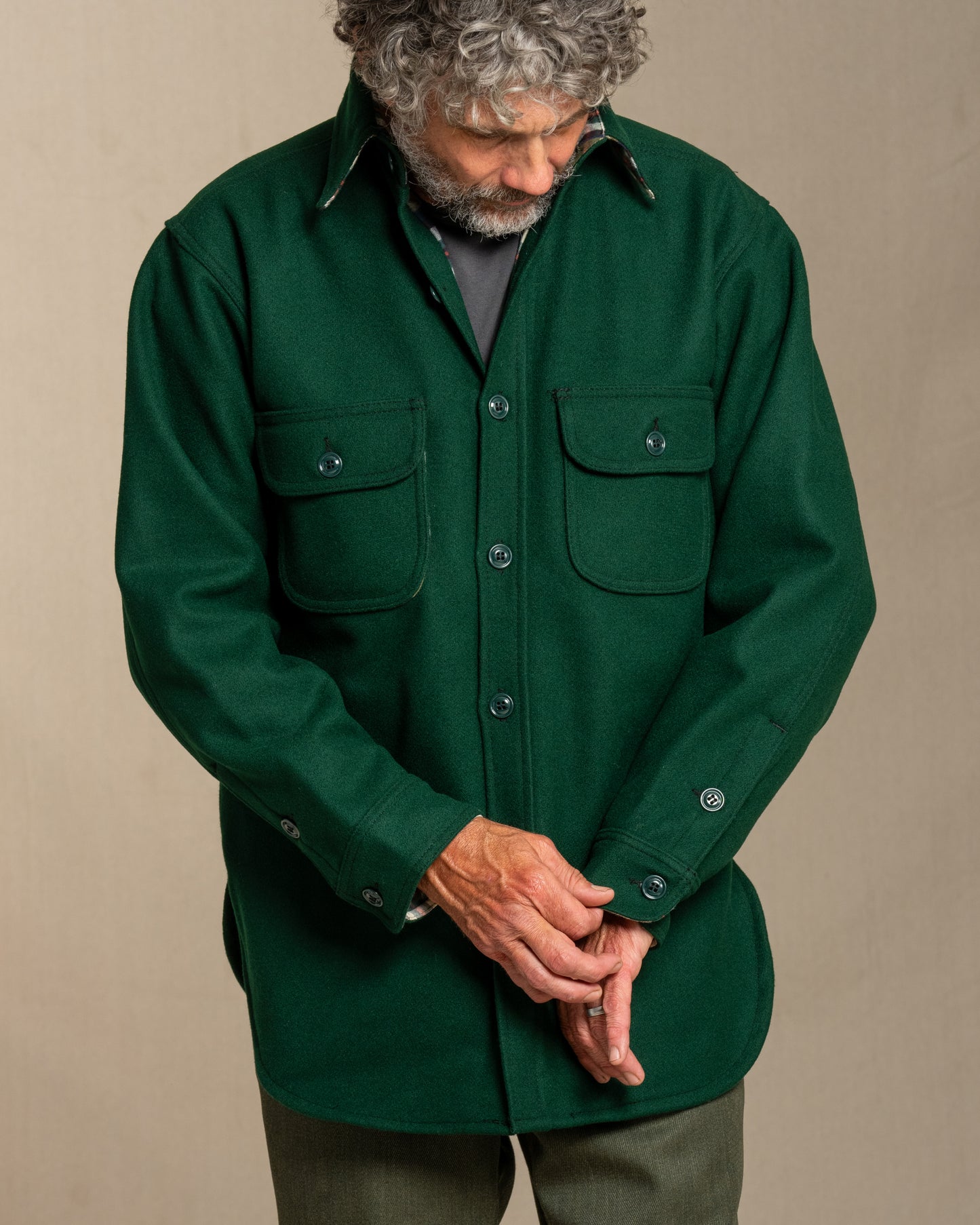 Man wearing a green wool shirt against a canvas background