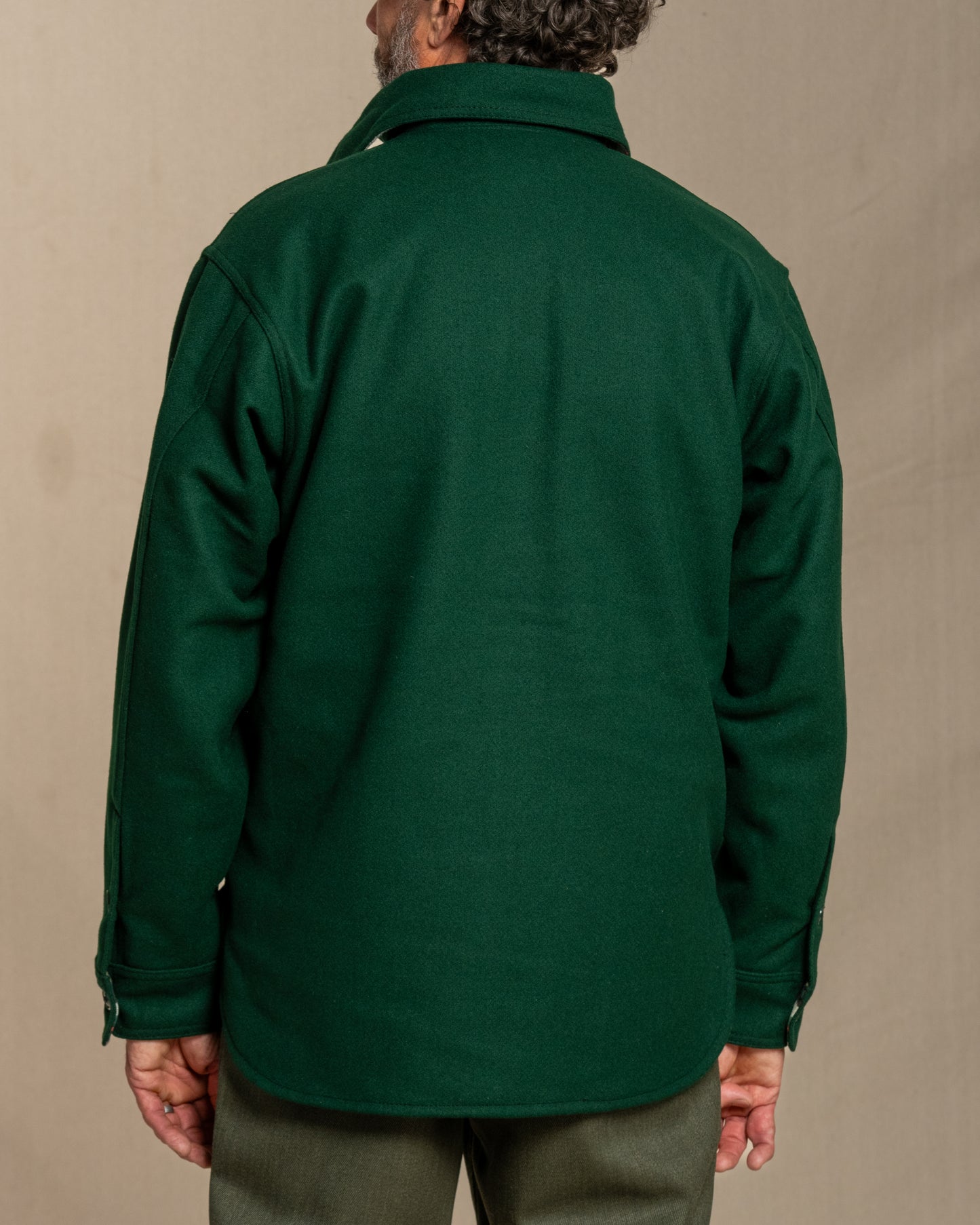 Man wearing a green wool shirt against a canvas background