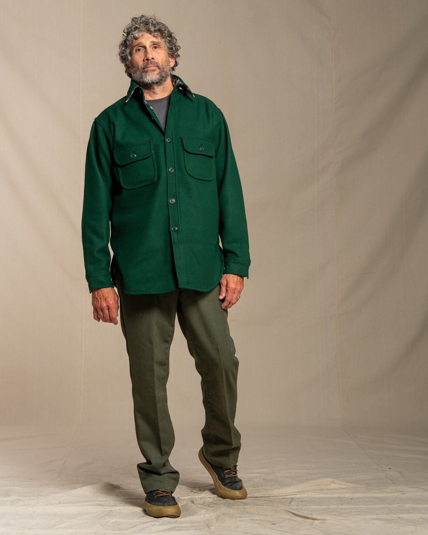 Man wearing a green wool shirt against a canvas background