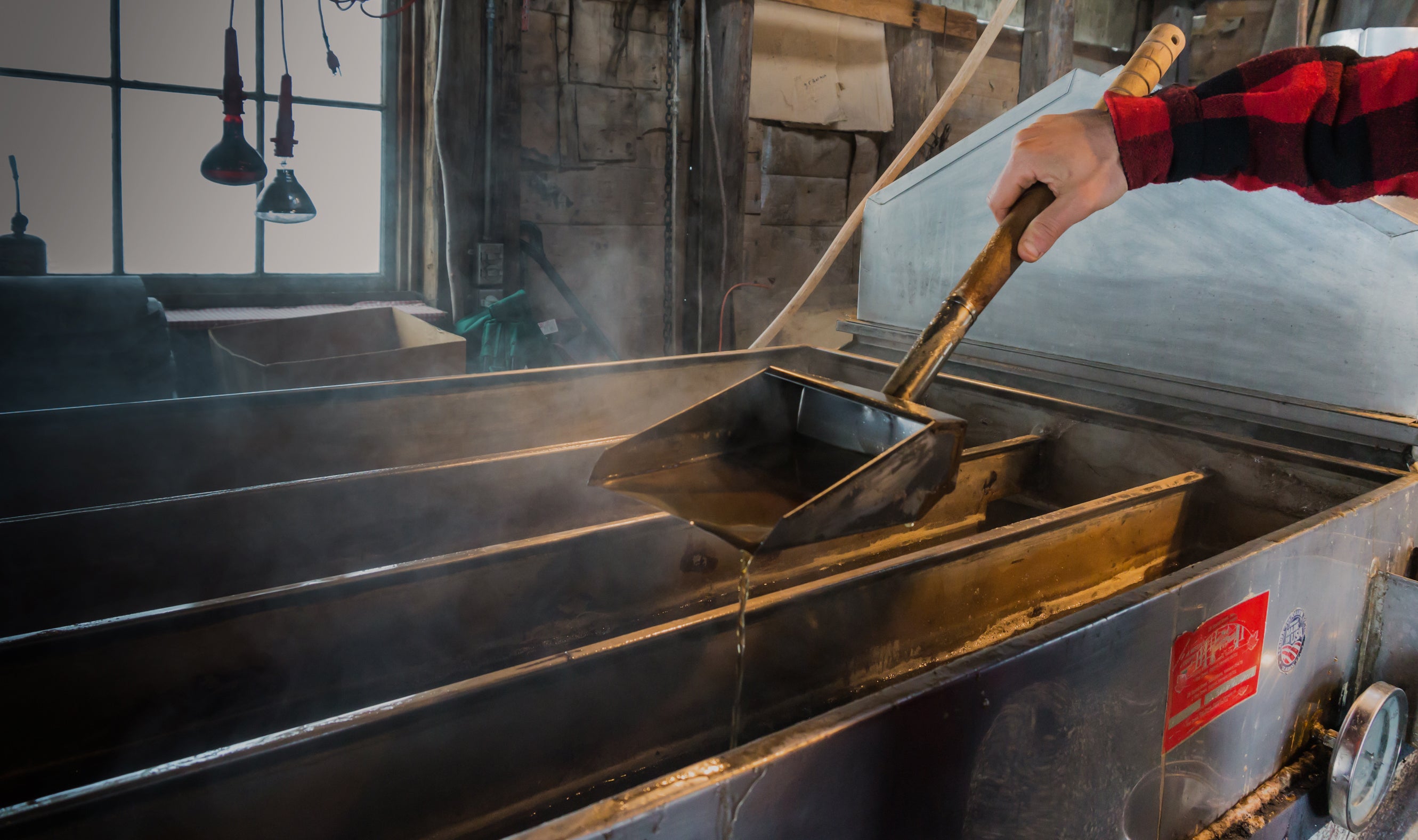 Person working with a maple syrup evaporator