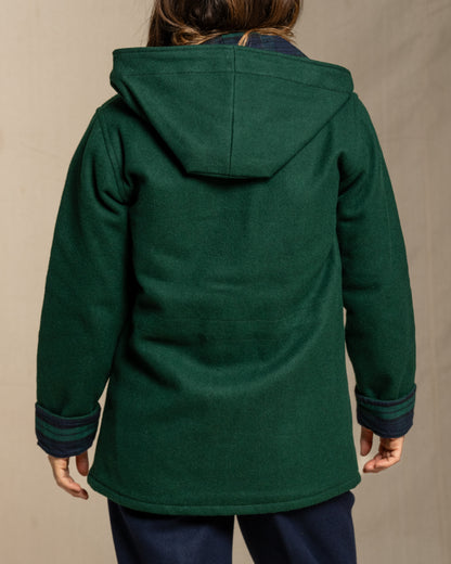 Green hooded wool coat worn by a person on a beige background