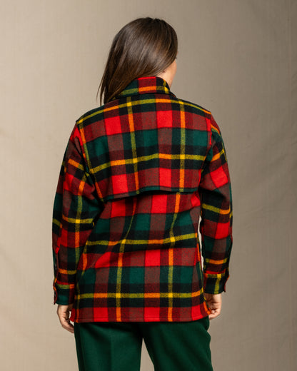 Woman wearing a red green and yellow plaid wool jacket against a neutral background