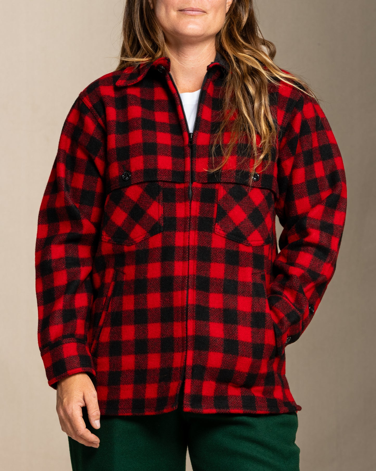 Person wearing a wool red and black jac shirt shirt against a neutral background