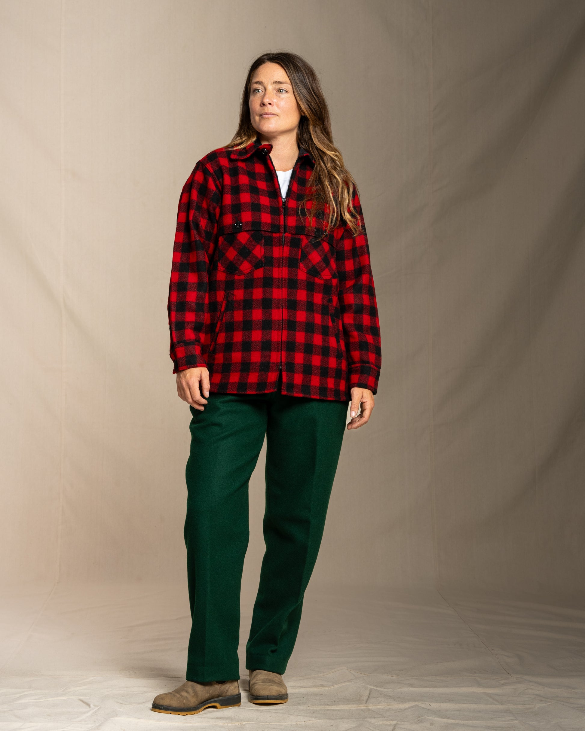 Person wearing a wool red and black jac shirt shirt against a neutral background