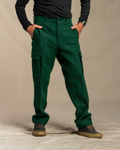 Green wool cargo pants worn by a person on a canvas background