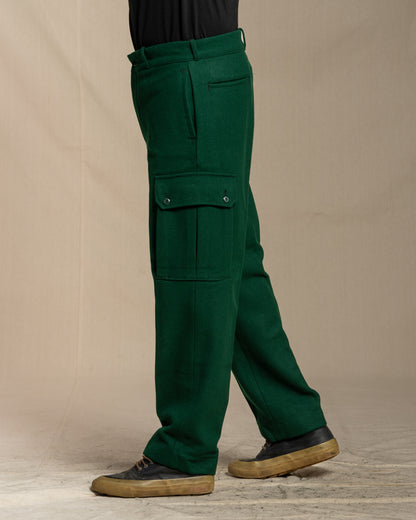 Green wool cargo pants worn by a person on a canvas background