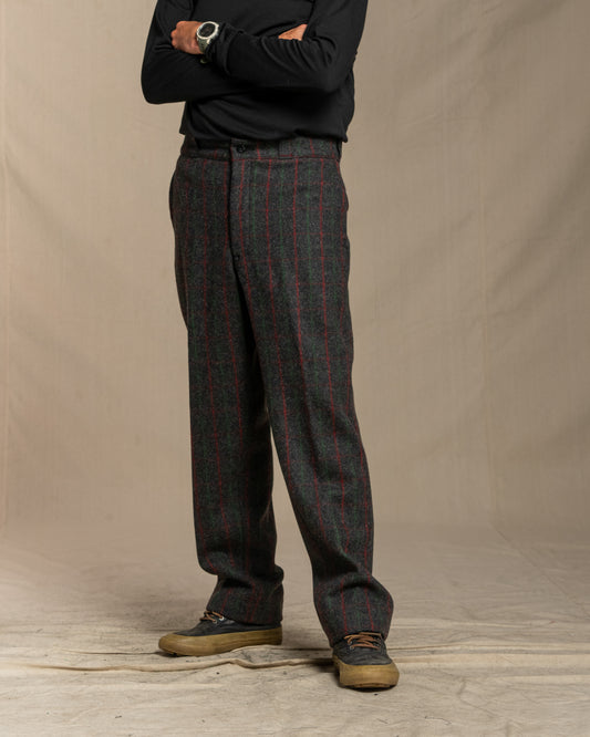 Person wearing Adirondack plaid pants and a black shirt against a beige background