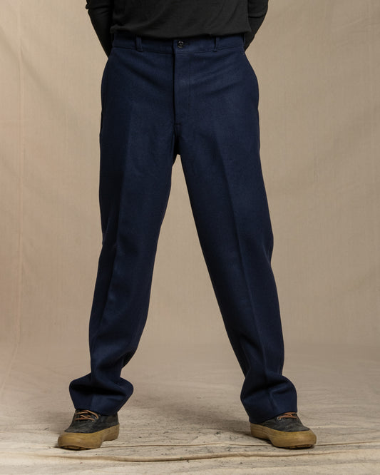 Navy blue wool pants worn by a person on a beige background