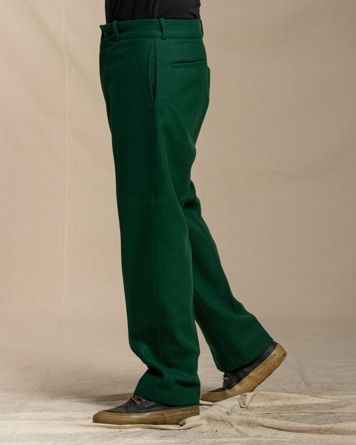 Green wool pants worn by a person on a canvas background