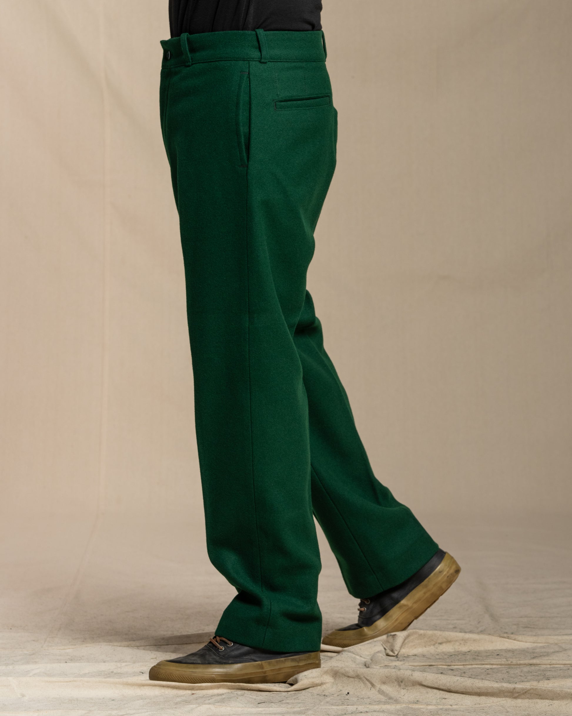 Green wool pants worn by a person on a canvas background