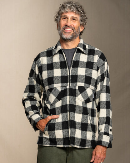 Man wearing a black and white checkered wool jacket against a plain background