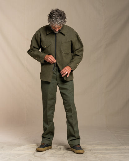 Man wearing a loden jacket against a beige background