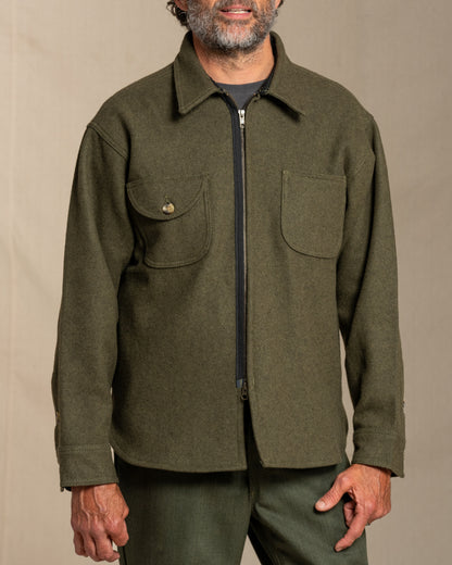 Man wearing a loden jacket against a beige background
