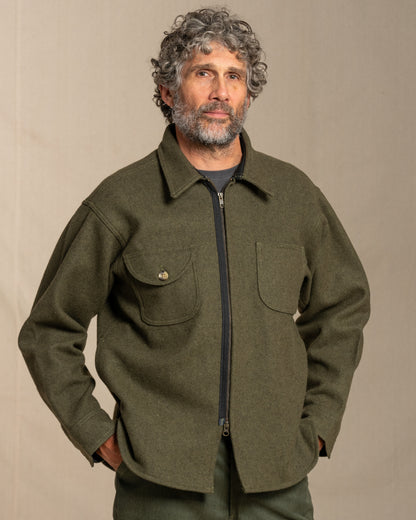 Man wearing a loden jacket against a beige background