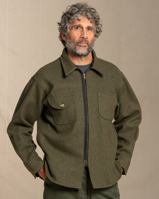 Man wearing a loden jacket against a beige background