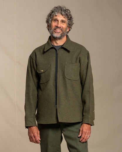 Man wearing a loden jacket against a beige background