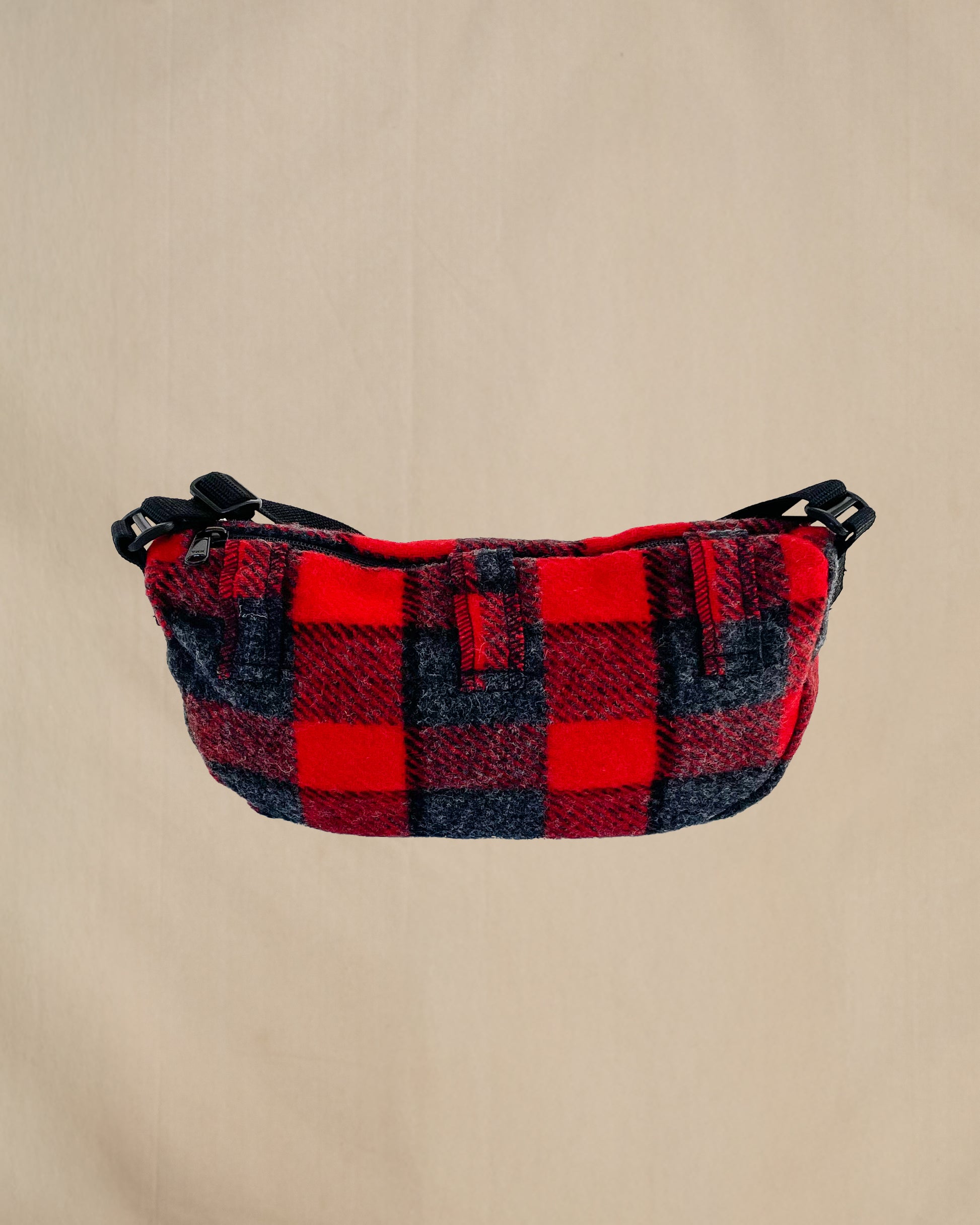 Wool sidewinder bag with strap - bag with zipped closure and belt loops for wearing on your waist plus shoulder strap. Shown in red and gray plaid, back view